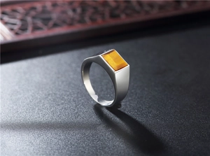 Macro detail of men's stainless steel signet ring featuring a rectangular tiger eye stone