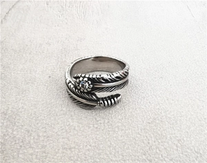 Close-up of vintage titanium steel feather ring with oxidized finish and zircon inlay