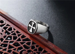 Macro side view of vintage stainless steel signet ring with black maltese cross shield