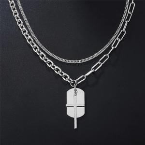 Collana punk multistrato argento con ciondoli a croce e piastrina su sfondo grigio scuro