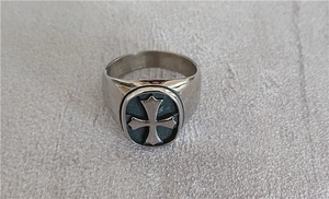 Macro view of retro stainless steel ring with black oval maltese cross engraving