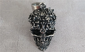 Detailed close-up of punk style skull pendant with intricate skeletal textures in vintage silver