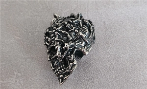 Macro shot of gothic skull pendant with detailed human figure carvings in vintage silver finish