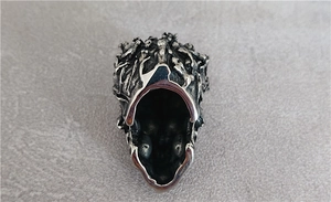 Detail of punk skull pendant featuring oxidized silver vine texture and polished inner wall