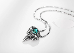 Detailed macro view of silver beast claw pendant with blue dragon eye on box chain