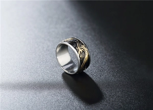 Détail d'une bague dragon vintage avec dragon doré sur une surface noire texturée