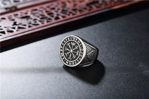 Macro detail of Nordic Viking Vegvisir compass and Valknut symbols on vintage steel ring