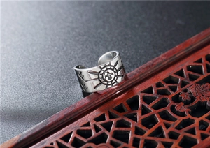 Detailed relief of an eagle and sun totem on a vintage punk style stainless steel ring