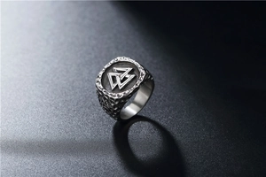 Detail of vintage silver Viking Valknut ring with hammered texture on stainless steel band