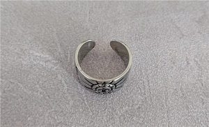 Detailed top view of vintage punk eagle ring with cross pattern on stone surface