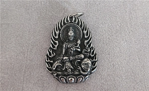 Detail of vintage silver Buddhist pendant featuring Samantabhadra Buddha on an elephant