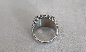 Macro shot of silver stainless steel ring featuring vintage textured pit design