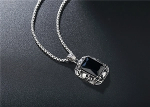 Détail des reliefs de crâne gothique sur cadre argenté avec pendentif en pierre noire