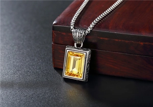 Dettaglio macro della cornice vintage in argento con gemma gialla su legno