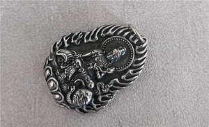 Detailed close-up of a vintage Guanyin Buddhist pendant in silver-tone stainless steel