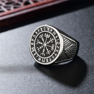 Vintage stainless steel Viking compass signet ring with runes on a dark textured surface
