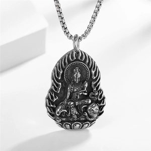 Polished silver stainless steel Guanyin Buddha pendant necklace on a geometric display