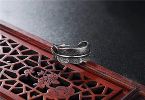 Macro shot of vintage style stainless steel feather ring showing intricate texture details