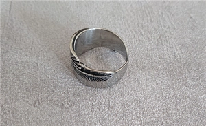 Detailed macro view of the retro feather texture and silver metal carving on the ring band