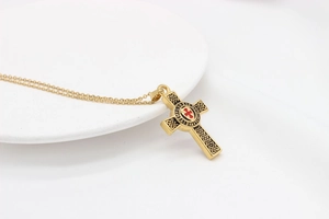 Nahaufnahme des goldenen Tempelritterkreuz-Anhängers mit rotem Inlay und Gravur