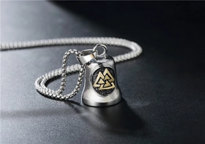 Macro shot of Viking bell pendant with gold Valknut symbol on silver box chain