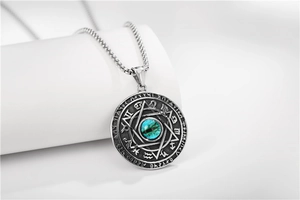 Detailed macro view of vintage stainless steel pendant with hexagram and teal eye