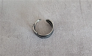 Macro shot of vintage style stainless steel feather ring with detailed silver textures
