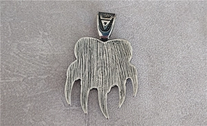 Close-up of oxidized silver Viking pendant with brushed metal texture and tribal claw design