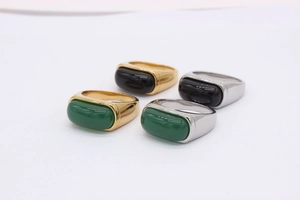 Detailed close-up of retro rectangular emerald and black agate stone saddle rings