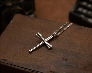 Detalle del colgante de bate de béisbol cruzado en acero sobre fondo de madera vintage