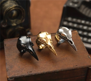 Macro view of gothic woodpecker skull rings in black, gold, and vintage silver finishes