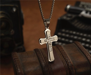 Détail du collier croix punk avec zircons carrés sur un fond en cuir vintage