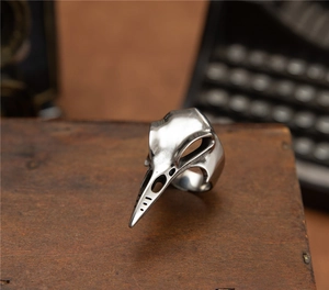 Macro shot of a punk woodpecker skull ring with vintage silver finish on a wooden surface