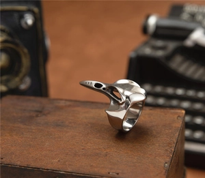 Macro shot of gothic steampunk crow skull ring on a vintage wooden case surface
