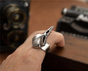 Macro shot of gothic woodpecker skull ring with vintage silver finish on wood surface