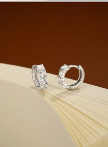 Détail de boucles d'oreilles créoles S925 en argent avec zircon carré sur une page