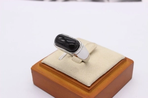 Macro shot of polished rectangular black agate stone set in wide silver metal band