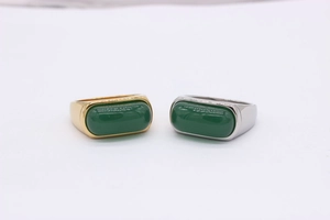 Macro shot of rectangular green agate stone set in gold and silver mens saddle rings