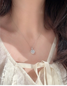 Gros plan du collier pendentif flocon de neige avec pierre scintillante sur dentelle