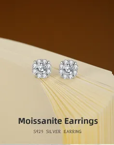 Macro shot of S925 silver flower-shaped moissanite studs on a book edge