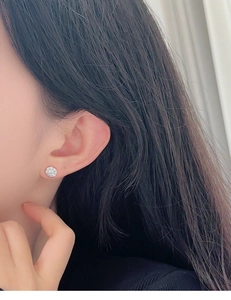 Macro side view of a model wearing sparkling flower-shaped S925 silver stud earrings