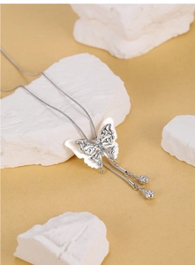 Macro view of S925 silver butterfly pendant with white shell and elegant tassel chains
