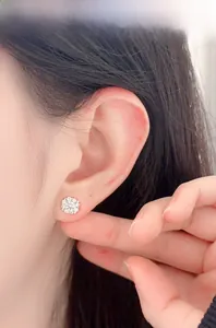 Close-up of S925 silver flower stud earring with moissanite stones on a female ear