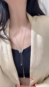 Macro shot of silver butterfly long necklace with textured wings and dual hanging chains
