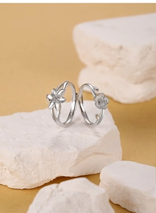 Gros plan de bagues ouvertes en argent S925 avec motifs de lys et fleurs de cerisier