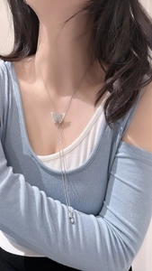 Detailed view of S925 sterling silver butterfly Y-shaped long sweater necklace on model