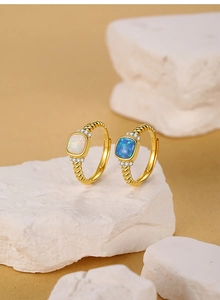 Detalle del sello S925 en anillos dorados con piedras de opalo azul y blanco puro