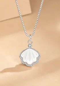 Detail van S925 zilveren ketting met witte parelmoer hanger en ingelegde zirkonia's