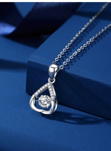 Macro-opname van een glinsterende S925 zilveren moissanite hanger op blauw fluwelen kussen