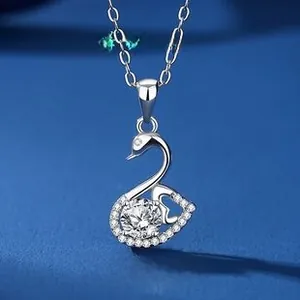 Macro shot of silver swan pendant with brilliant zircon and heart hollow detail